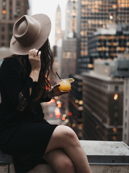 Woman with a drink overlooking NYC