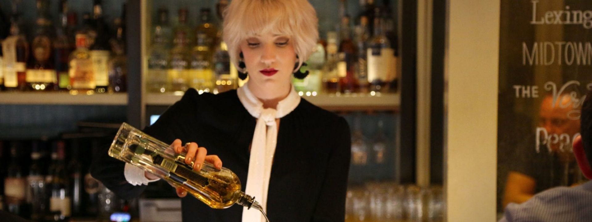 A bartender mixing a drink at The Benjamin Hotel in NYC